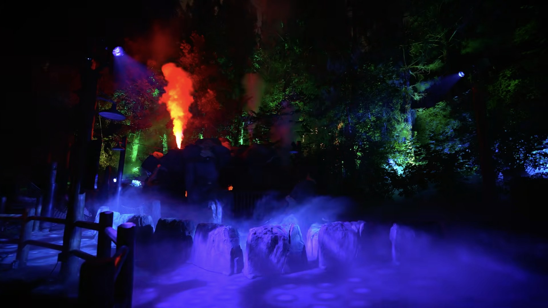 A plume of orange smoke rising above blue fog and green lighting inside Villains Grove. | CREDIT: Disney