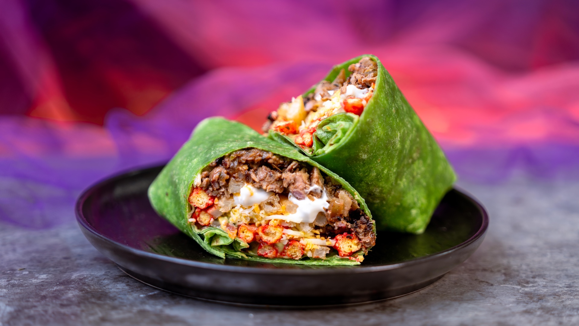 The Spicy Oogie Boogie Burrito served in a green tortilla at Studio Catering Co. | CREDIT: Disney